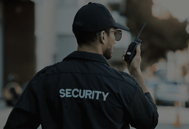 Security guard communicating via handheld radio.
